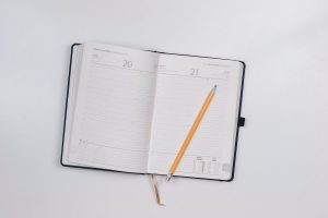 Photo of a day planner opened with a pencil inside.