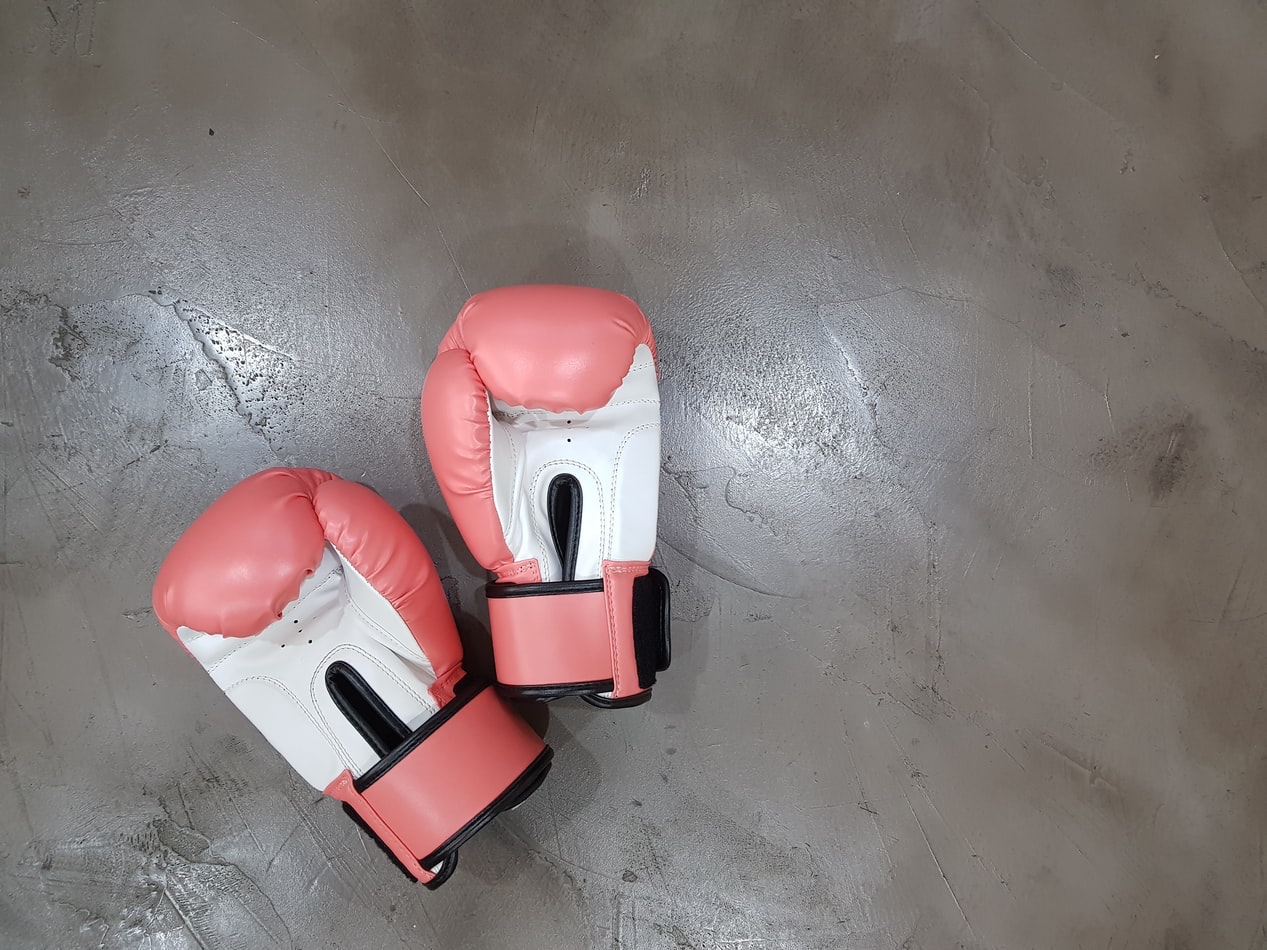 Photo of two pink and white colored boxing gloves.