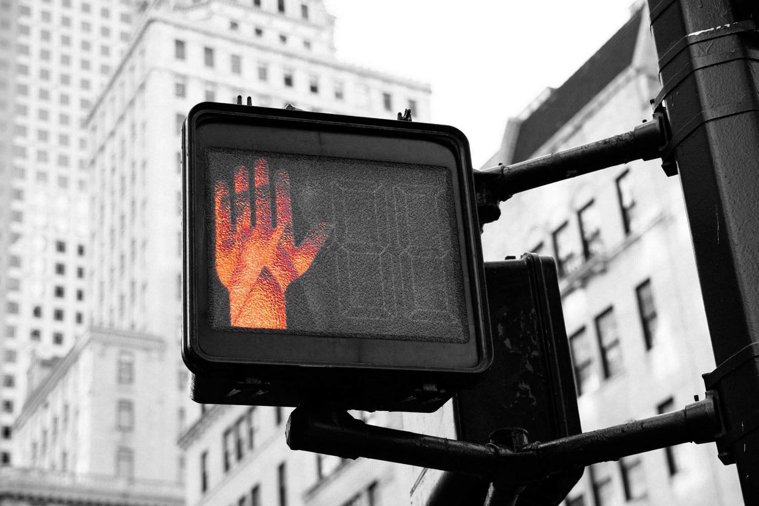 A photo of an intersection pedestrian crossing sign with the red hand displayed.