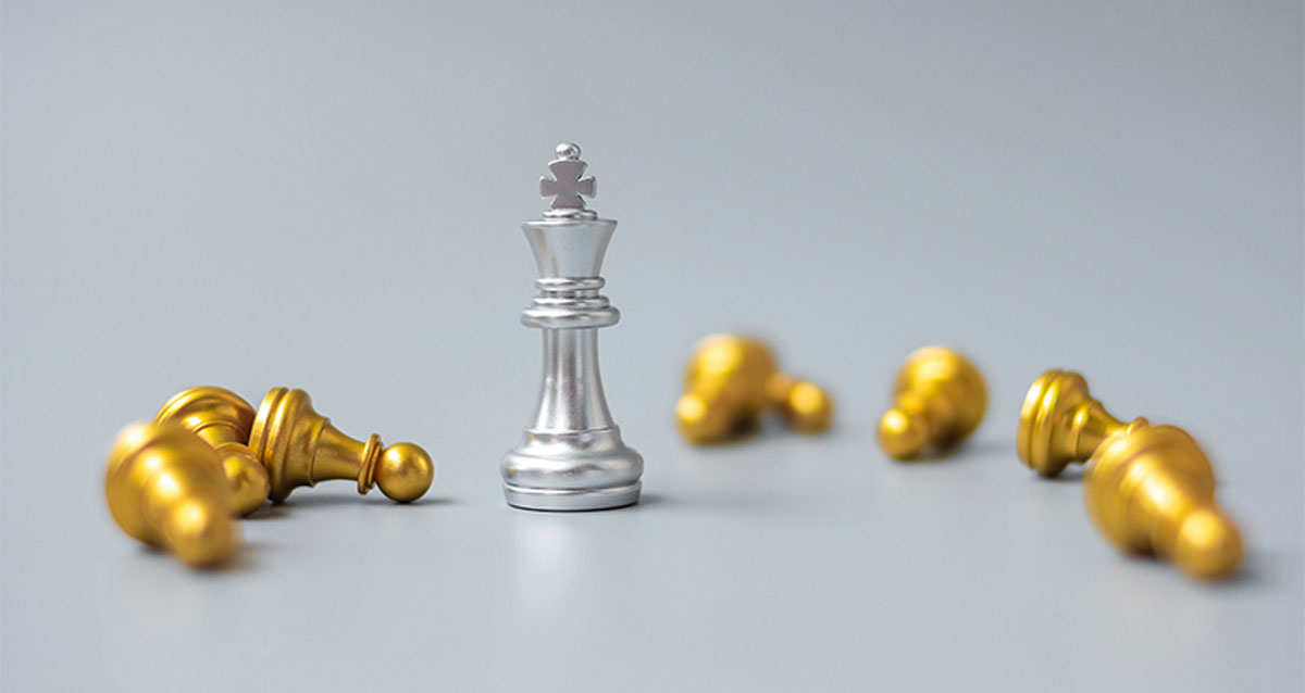 Chess pieces. A king standing surrounded by eight fallen pawns.