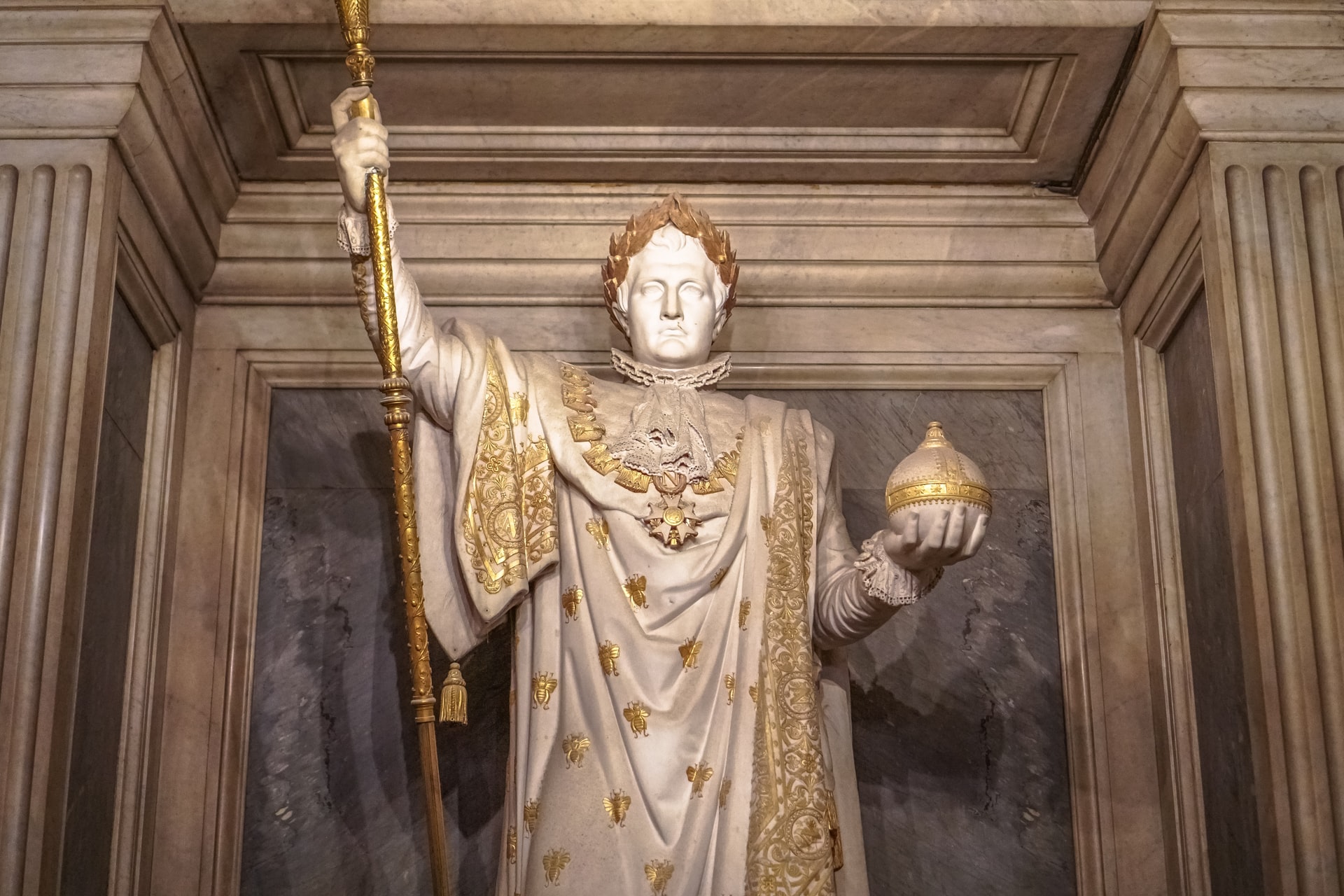 Image of a statue of and emperor holding a staff and an orb.