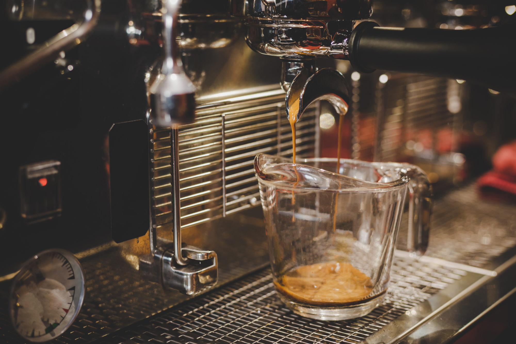 Photo of a coffee brewing machine and a measuring cup.